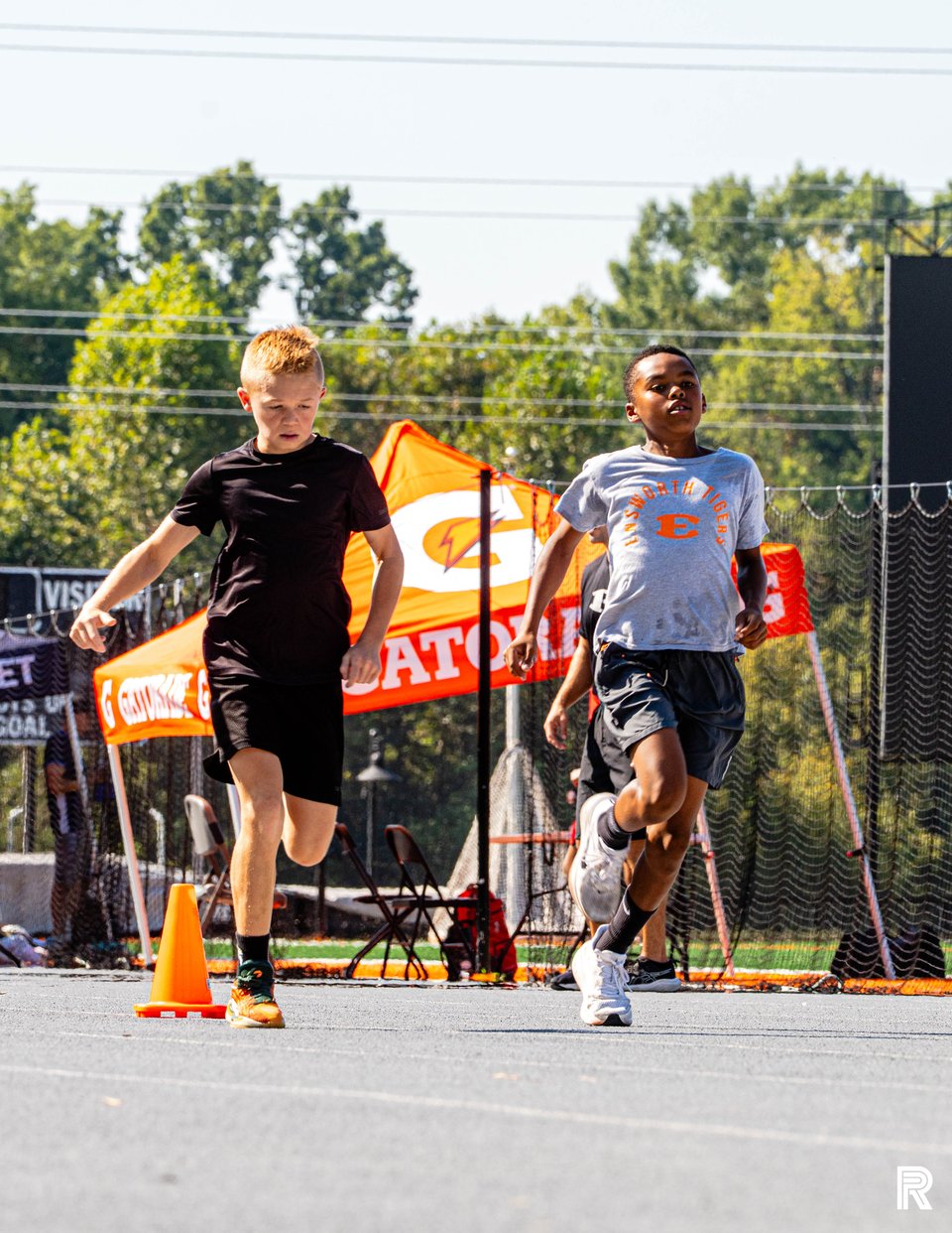 Two athletes move through a sprint drill on the outdoor track