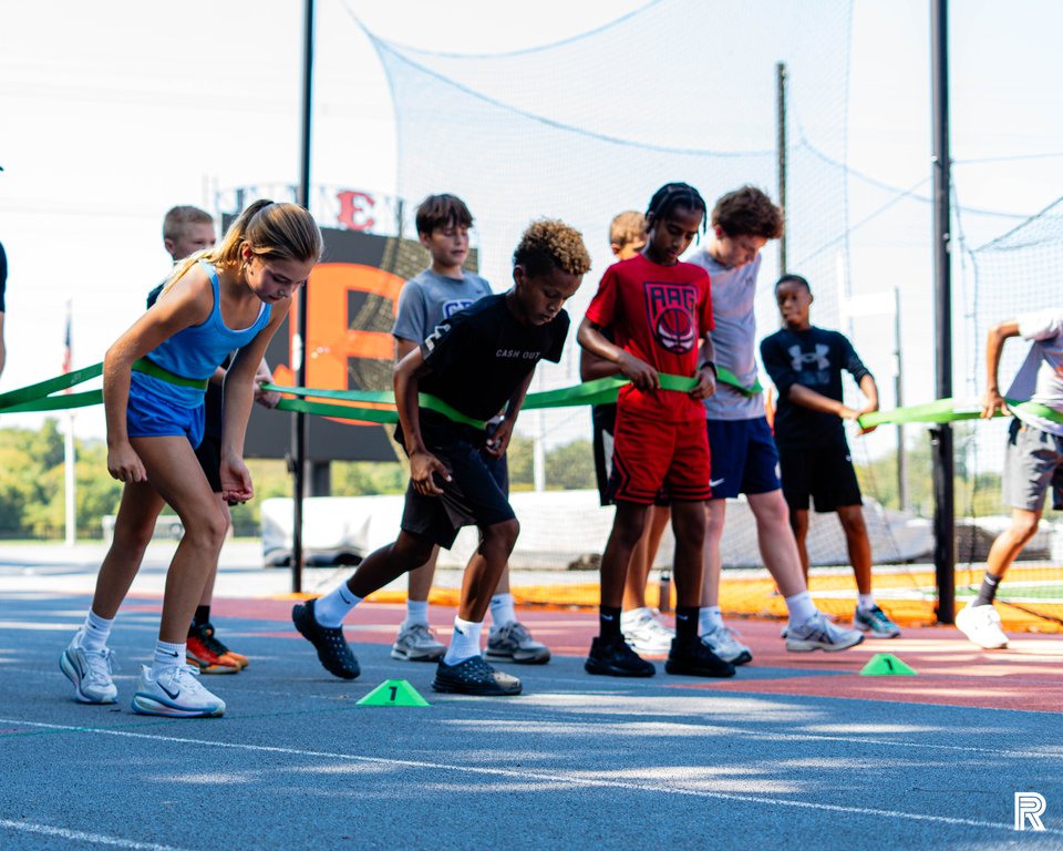 Athletes practice coordinated sprint starts together at a previous outdoor Jet training session